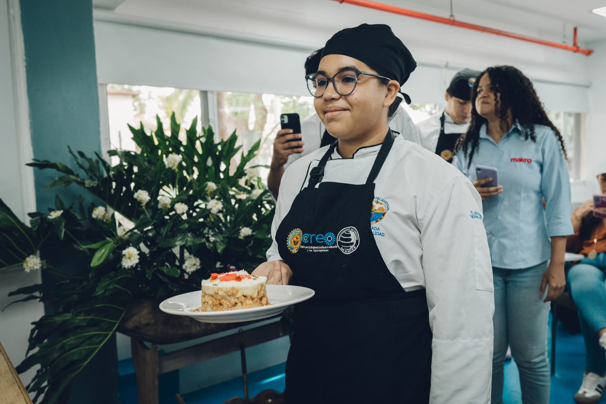 Estudiante de gastronomía presenta un plato de cocina del mar en una muestra del evento.